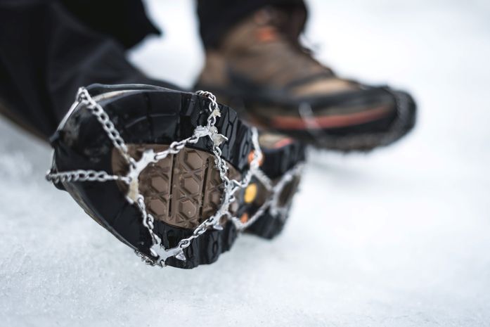 Crampons tied up on hiking boots.