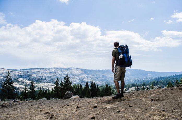 A hiker carrying a backpacking backpack