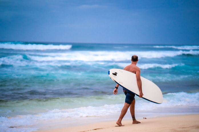 A surfer at the North shore in Waialua, Hawaii